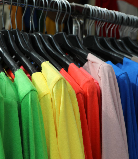 molte camicie colorate appese al gancio in vendita
 - Foto, immagini