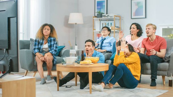 In the Living Room Diverse Group of Friends on Watching Sports Game Match on TV, They Cheer and Chant for the Team, But are Disappointed after Team Loses. Cozy Room with Snacks and Drinks - Φωτογραφία, εικόνα