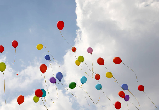 Gruppe von Ballons fliegen in den blauen Himmel mit vielen weißen Wolken i - Foto, Bild