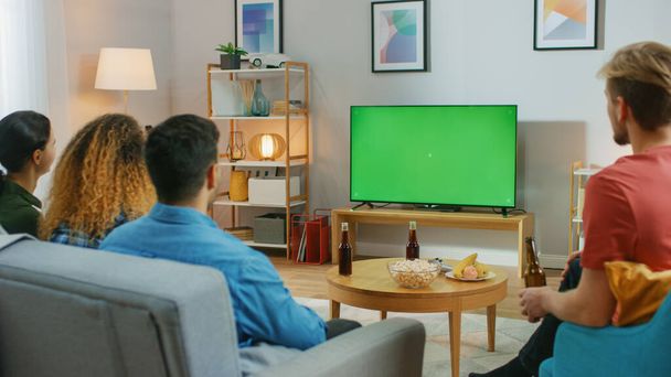 Happy Friends Sitting At Home Watching Green Chroma Key Screen, Relaxing on a Couch. Watching Sports Match, News, Sitcom TV Show or a Movie. - Φωτογραφία, εικόνα