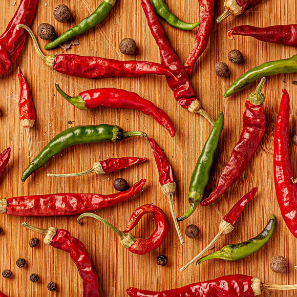 Red and green chili peppers on a wooden board. - Photo, Image