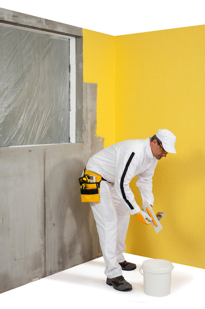 Trabalhador na frente da parede rebocada
 - Foto, Imagem