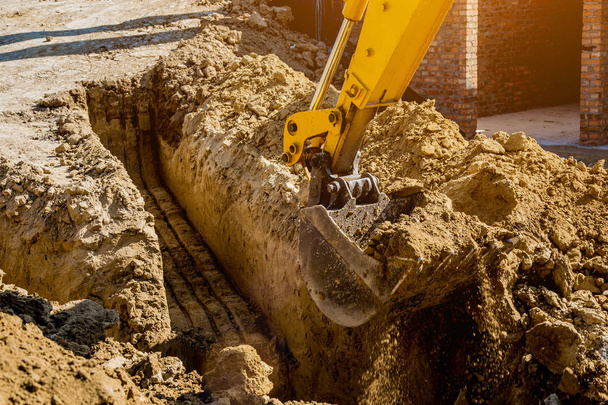 Working Excavator Tractor Digging A Trench At Construction Site. - 写真・画像