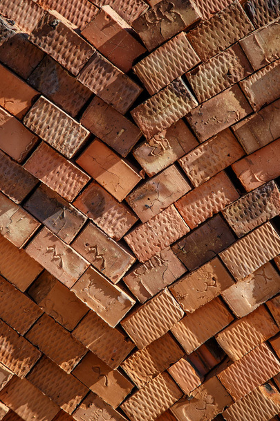close-up de pacote de tijolos de argila laranja fica perto da construção
 - Foto, Imagem