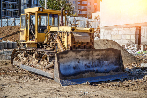 Yellow Bulldozer on new construction site, with the bright sun a - 写真・画像