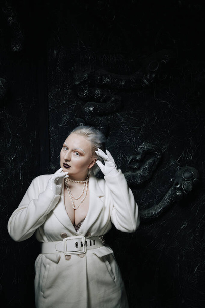 portré szokatlan lány fehér ruhában fekete háttér a stúdióban. nő plusz méret albínó. a szépség fogalma minden emberben - Fotó, kép