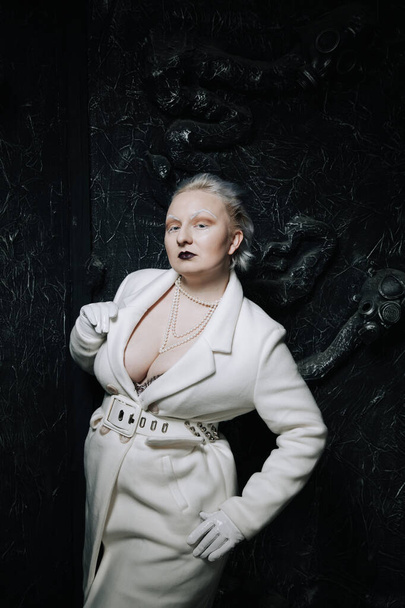 portrét neobvyklé dívky v bílém oblečení na černém pozadí ve studiu. žena plus velký albín. koncept krásy u každého člověka - Fotografie, Obrázek
