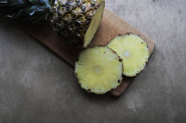 Ananas auf Holzbrett schneiden - Foto, Bild