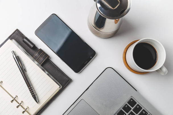primer plano de teléfono inteligente, portátil, nota y taza de café. concepto de negocio y lugar de trabajo. herramientas freelancer aisladas
  - Foto, imagen