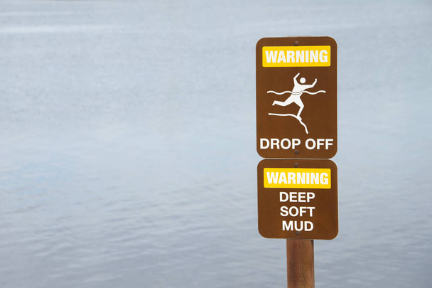 Señal de advertencia cerca del acantilado por el borde de las aguas. Agua en backgr
 - Foto, imagen