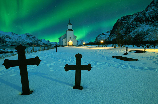 Північне сяйво над зимовим пейзажем з церквою і кладовищем
 - Фото, зображення