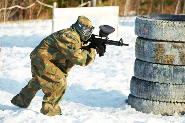 Paintball player with marker at winter outdoors - Foto, Imagem