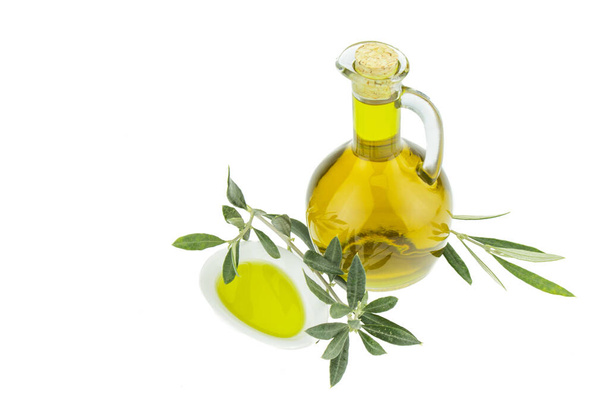 Oliiviöljy Pullo ja kulho lautasen oliivipuun oksa. Neitsytoliiviöljy. Luonnollinen oliiviöljy, terveellinen ruoka. Luonnollista välimeren ruokaa. Leipädippaus
. - Valokuva, kuva