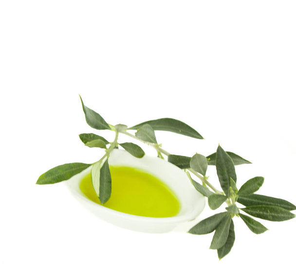 Olivenölflasche und Teller mit Olivenzweig. natives Olivenöl. natürliches Olivenöl, gesunde Ernährung. natürliche mediterrane Kost. Brotdippen. - Foto, Bild