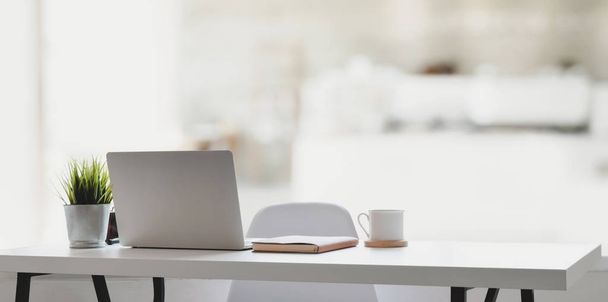 komfortabler Arbeitsplatz mit Laptop, Kaffeetasse und Bürobedarf in entspannter Atmosphäre   - Foto, Bild