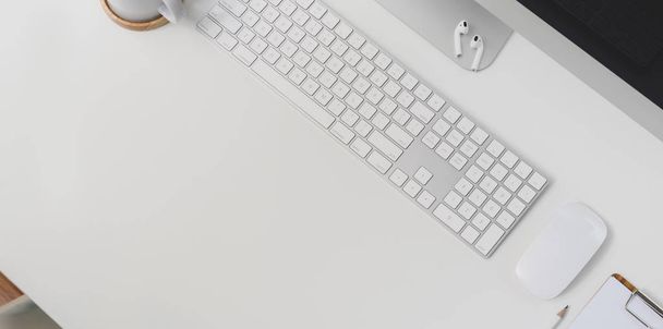 Top näkymä moderni työpaikka näppäimistö tietokone ja toimistotarvikkeet valkoinen pöytä tausta kopioi tilaa
  - Valokuva, kuva