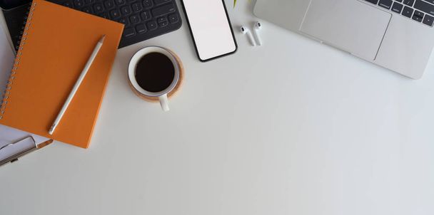 Górny widok wygodnego miejsca pracy z pustym ekranem smartfon na białym drewnianym biurku z materiałami biurowymi i miejsca do kopiowania  - Zdjęcie, obraz
