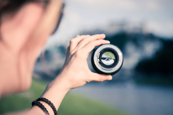 Photographer holds a professional photo optic in his hand - Foto, imagen