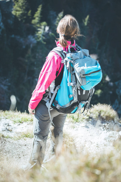 young  woman hiker climbing on rock on mountain peak cliff  - Foto, Bild