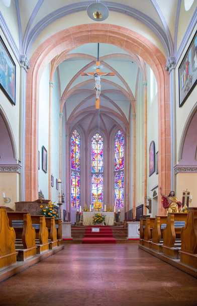 Inside of a large, modern church with pews and cross visible  - Foto, Imagen