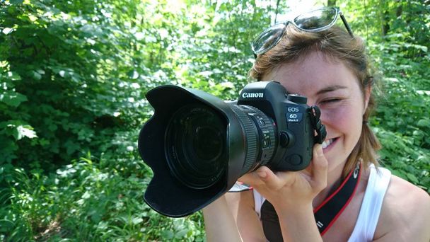 Young woman, professional photographer, taking pictures of a beautiful nature - Foto, Imagem