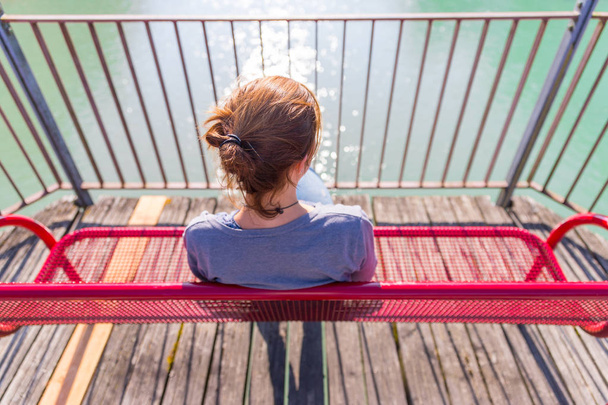 Beautiful young woman  sitting on a bench  - Фото, зображення