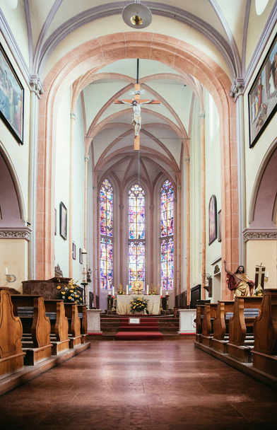 Uvnitř velkého, moderního kostela s lavicemi a křížem viditelným  - Fotografie, Obrázek