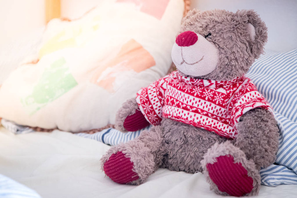 Cute teddy bear toy is sitting in the bed, wakeup at morning, sunlight - Photo, image