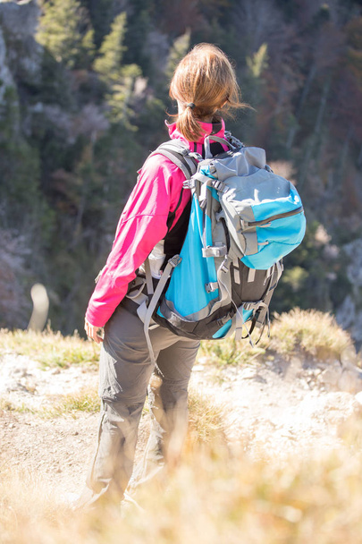 young  woman hiker climbing on rock on mountain peak cliff  - Φωτογραφία, εικόνα