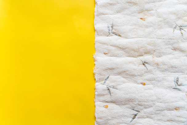 Top view of crumpled Japanese paper (Washi) on yellow paper in 50/50 ratio. Paper texture background with copy space. - Photo, Image