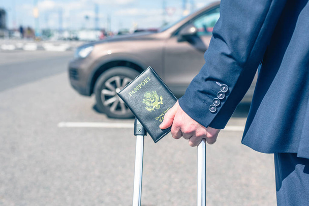 Man pilot in a blue uniform (suit), suitcase and american passport. airport parking rental car. concept - Foto, imagen