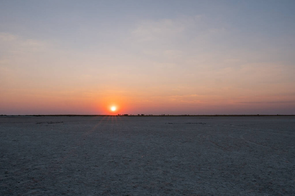 Auringonlasku Makgadikgadissa Suolapannu - tyhjä tasainen tasanko ja Hori
 - Valokuva, kuva