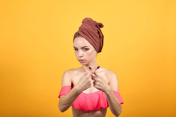 fiatal lány törölköző a feje fölött elkülönített narancssárga háttér mutatja érzelmek - Fotó, kép