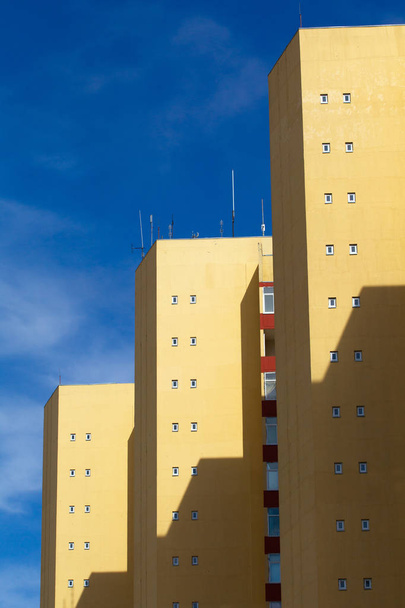 Gele hoogbouw op een achtergrond van blauwe lucht - Foto, afbeelding