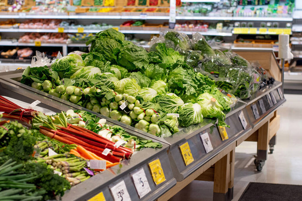 Friss zöldségek halmozódtak fel a szupermarketben. Étel háttér-csoportosítás. Szüret - Fotó, kép