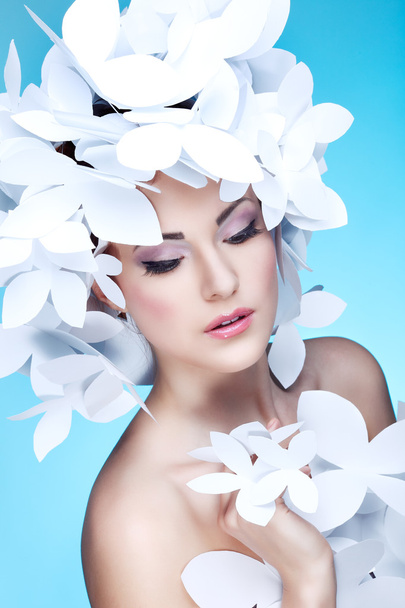 Wonderful girl in a hat from paper white butterflies. On a blue background. Beauty Face - Foto, Bild