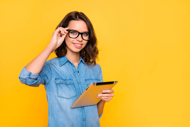 Portrait of confident cool expert freelancer smm in stylish eyewear use her tablet prepare work project wear denim jeans clothes isolated over yellow color background - Фото, изображение