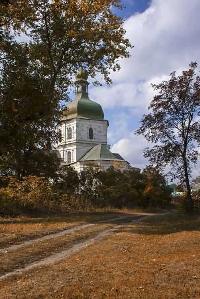 Antigua iglesia ortodoxa a través de árboles amarillos de otoño. Arquitectura histórica
. - Foto, imagen