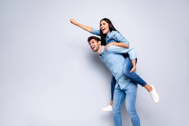 Photo of cool pair guy holding lady piggyback pretending flight up using super powers wear casual jeans clothes isolated grey color background - Zdjęcie, obraz