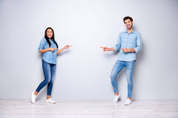 Full length photo of guy and lady advising buy new product for low price indicating fingers empty space wear casual jeans clothes isolated grey color background - Photo, Image