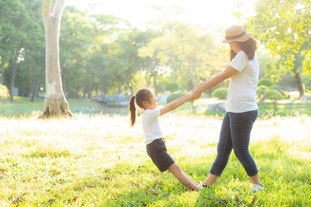 Young asian mother and little daughter playing the park with fun - Photo, Image
