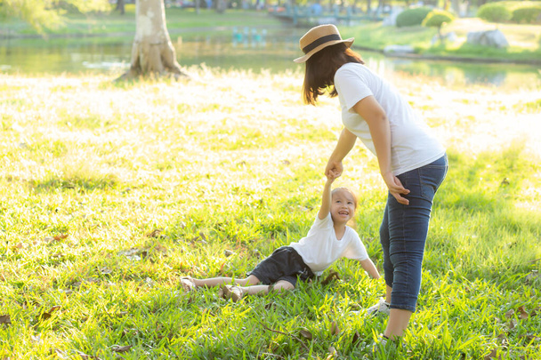Νεαρή Ασιάτισσα μητέρα και μικρή κόρη παίζουν στο πάρκο με διασκέδαση - Φωτογραφία, εικόνα