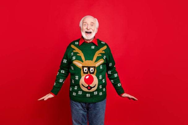 Wow christmas discounts. Portrait of funky old man hipster hear wonderful newyear seasonal sales scream omg wear traditional pullover with reindeer decor ornament isolated over red color background - Zdjęcie, obraz