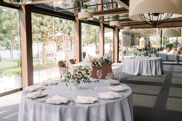 Hochzeitsbankett in einem stilvollen Saal mit Panoramafenstern zum Boden. - Foto, Bild