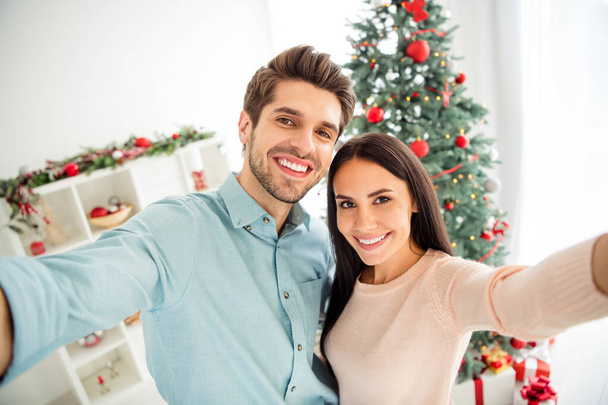 Close up photo of two romantic people married couple making selfie hugging enjoy christmas time x-mas holidays in white house indoors - Photo, Image