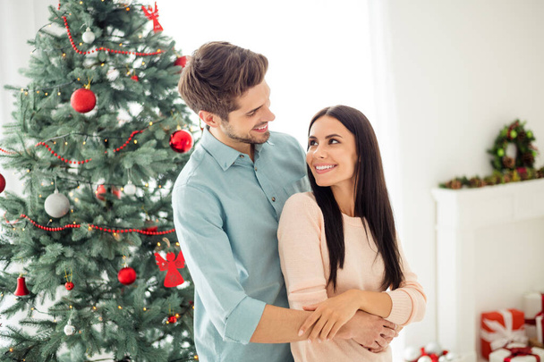 Portrait of two people romantic man and woman hug enjoy christmas time x-mas holidays in house with newyear decoration indoors - Foto, Imagem