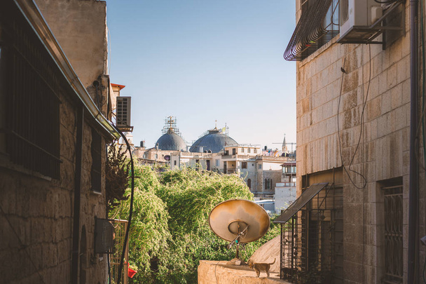 Ghetto hintere Straße Vordergrund städtisches Wahrzeichen Ansicht mit verlassenem Rost tv Antenne von jerusalem Altstadt mit Religion Kathedrale Kuppel auf dem Hintergrund  - Foto, Bild