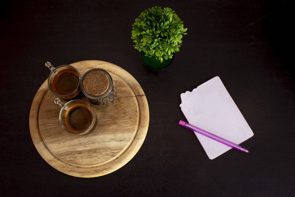 Taza de café en la mesa, con bolígrafo, Fondo negro
 - Foto, imagen