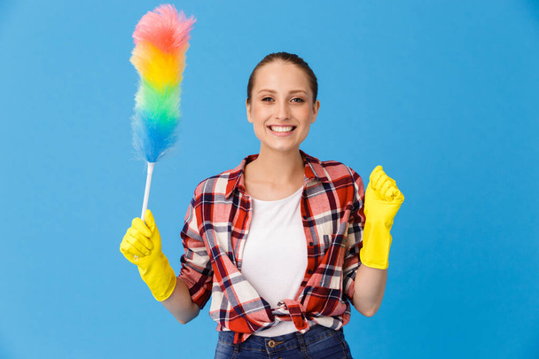 Portrait of happy housewife wearing yellow rubber gloves holding - Foto, immagini