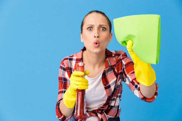 Portrait of uptight housewife in yellow rubber gloves holding de - Foto, afbeelding